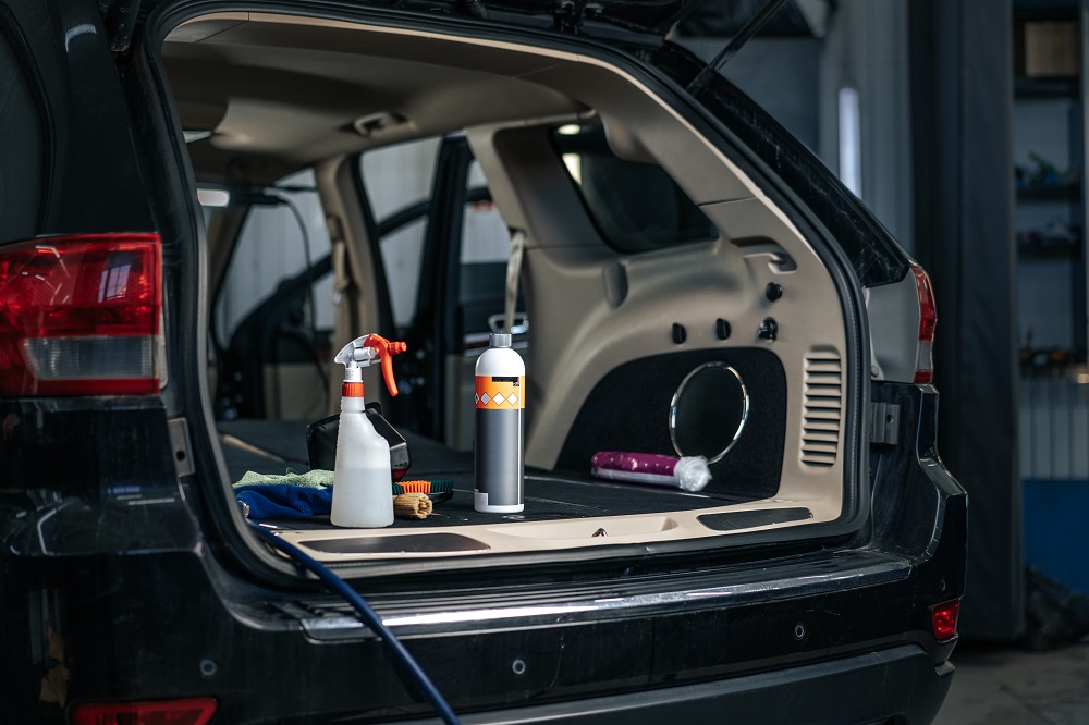 Open trunk of an SUV with cleaning supplies, including spray bottles, a cloth, and a vacuum, neatly arranged for car interior cleaning—perfect for Auto Detailing in Slidell.