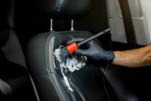 Hand washing car interior and seat by a soft brush with foam.